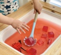 GLO PALS Glo Pals, Postać do kąpieli Sammy - zestaw z dwiema kostkami sensorycznymi świecącymi w wodzie - czerwony