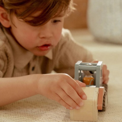 Dziecko bawiące sie drewnianą ciężarówką z dźwigiem Little Dutch z operatorem w środku