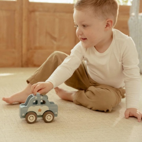 Dziecko bawiace sie drewnianym samochodem policjnym Little Dutch