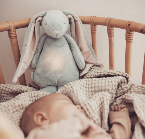 królik szumiący moonie z włączoną lampką w opakowaniu w łóżeczku