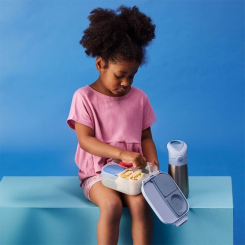 Dziewzcyna jedząca z lunchboxa B.box i bidonu termicznego B.box  chill out