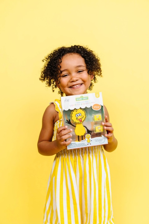 dziewczynka trzymająca Postać do kąpieli Glo Pals Wielki Ptak - zestaw z dwiema kostkami