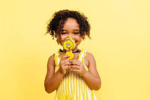 dziewczynka trzymająca w rękach Postać do kąpieli Glo Pals Wielki Ptak - zestaw z dwiema kostkami