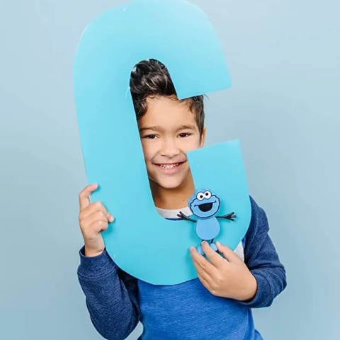 chłopiec trzymający Postać do kąpieli Glo Pals Ciasteczkowy Potwór - zestaw z dwiema kostkami