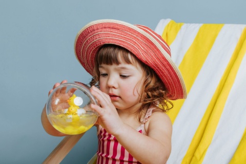 Kula sensoryczna Kaczuszka Petit Boum Happy Bubbles w rękach dziecka