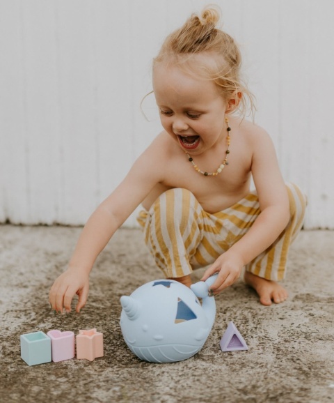 dziewczynka bawiąca się Morski Sorter Kształtów Jellystone Pastel silikonowy wieloryb