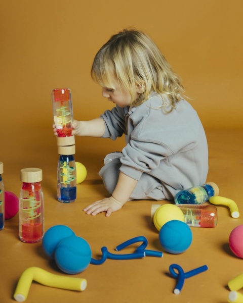 dziewczynka bawiąca się Niebieska Butelka sensoryczna dwufazowa Petit Boum Move Spirala