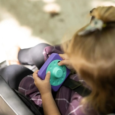 Sensoryczny Kwadrat Fat Brain Toy Co. PlayTab Tarcza Obrazkowa w rękach dziecka