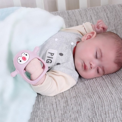 Gryzak pingwin Smily Mia jasnoróżowy - w rączce dziecka