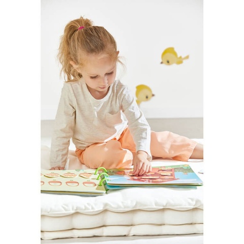 dziewczynka czytająca książeczkę z zadaniami Janod Busy Book Farma